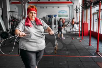 Fat sweaty woman, fitness exercise with rope in gym. Calories burning, obese female person on a training in sport club, obesity