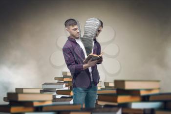 Sawn in half man reading among books and textbooks. Gaining knowledge and education concept