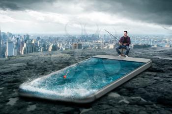 Phone addicted people concept. Man fishing in the smartphone screen with water, cityscape on background. Scaling effect