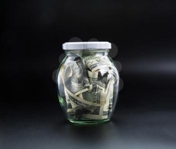 Money saving concept, glass jar full of dollars. Cash economy, home bank
