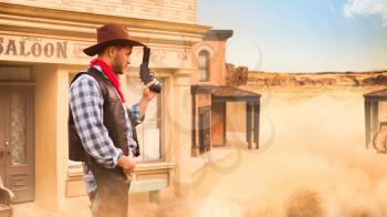 Brutal cowboy with revolver, gunfight against saloon, western. Vintage male person with gun, wild west lifestyle