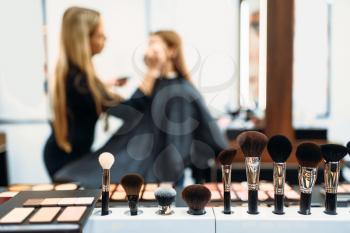 Makeup artist works with customers face, woman in make-up shop. Female client in beauty salon