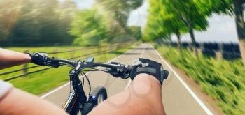 Man riding on bicycle, fast speed, aging effect. Cyclist biking on bike path in summer day