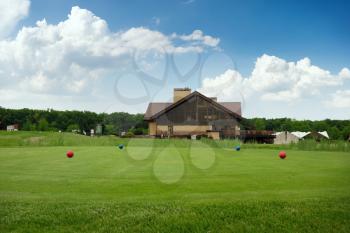 Four color balls on golf course, launching pad, nobody. Green meadow in sport club, trimmed lawn for game, empty playground