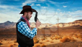 Cowboy with revolver prepares to gunfight in gesert valley, western. Vintage male person with gun, wild west lifestyle