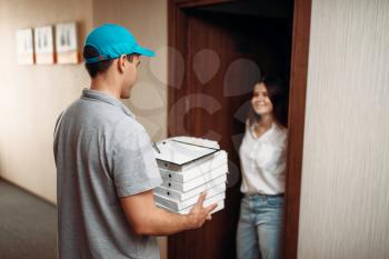 Female customer on the doorstep and pizza delivery boy, delivering service. Deliver from pizzeria and woman indoors