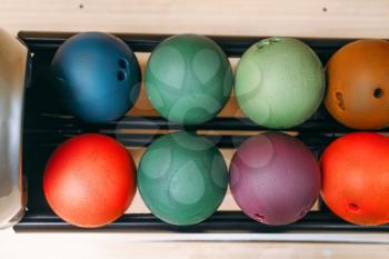 Rows of color bowling balls in feeder, top view, nobody. Bowl game concept
