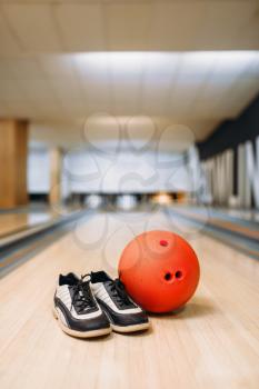 Bowling ball and house shoes on lane in club, pins on background, nobody. Bowl game concept, tenpin