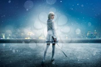 Anime style blonde girl with sword on the snowy edge of the skyscraper roof, back view. Cosplay woman, asian culture, doll with blade in cold tones, night cityscape on background