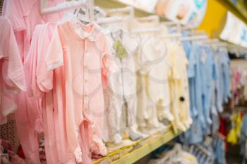 Store for newborns, sliders in cloth department, nobody. Baby wear in shop of goods for infants