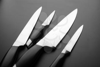Collection of kitchen knives on black bfckground. Set of professional blades for cutting food
