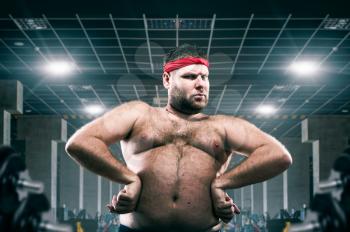 Fat athlete on workout in fitness club, fatness. Overweight problem, training in gym motivation