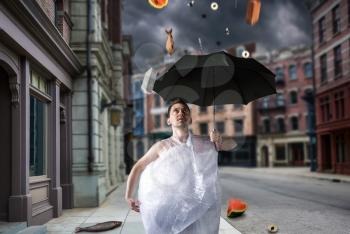 Naked freak man wrapped in packaging film walks with umbrella, fantasy rain. Crazy male person on city street