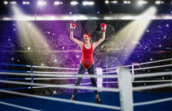 Female boxer in red bandages and sportswear hands up on the ring, side view. Woman on boxing ring