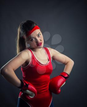 Portrait of female boxer in red boxing gloves. Fighting sport and martial art concept