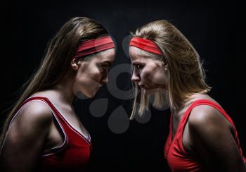 Two female boxers in red sportswear standing face to face. Fighting sport and martial art concept
