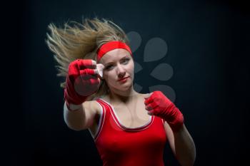 Female boxer in red boxing bandages and sportswear training. Fighting sport