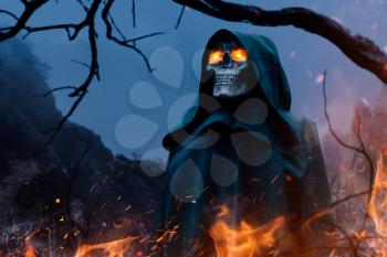 Death in a black hoodie with burning eyes in forest. Horror style, fear, spooky evil