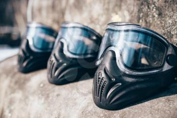 Paintball masks with glasses closeup, nobody. Extreme game protection equipment, sport ammunition