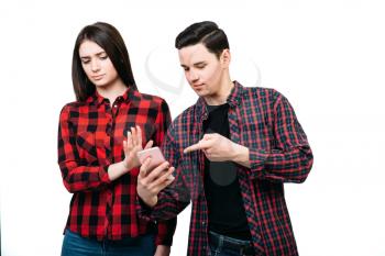 Relationship of smartphone addicted people concept. Man shows on phone screen, woman don't like it, white background