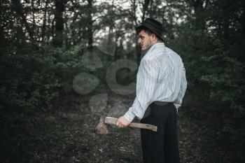 Serial murderer with an axe in the night forest, bloody maniac concept, crazy monster, crime and violence