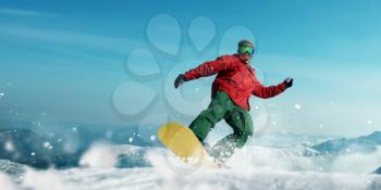 Snowboarder makes a jump, front view, sportsman in action. Winter active sport, extreme lifestyle. Snowboarding in mountains, blue sky on background