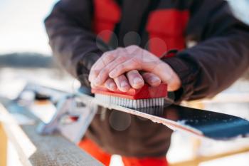 Male skier hands prepares skis for riding. Winter active sport, extreme lifestyle. Downhill skiing