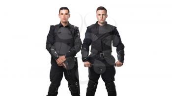 Special force troops with a gun and a baton in black uniform and body armor on white background. Two police officers in special ammunition