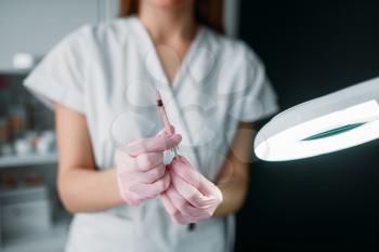 Beautician with syringe in hands against female patient, botox injection, getting rid of wrinkles, cosmetology clinic. Facial skincare, rejuvenation procedure in spa salon, health care