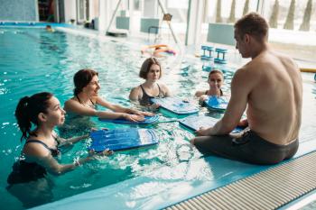 Male trainer works with female aqua aerobics group on workout in swimming pool. Water sport