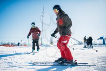 Beginners learn to ski, skiers in equipment, winter active sport. Skiing from mountains, extreme lifestyle