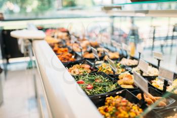 Fresh cooked food in store, nobody. Showcase with prepared salads and meat products in market