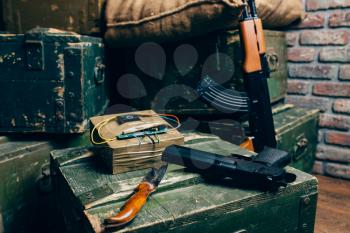 Bomb, knife, gun and kalashnikov rifle on box of ammunition, nobody. Terrorism and terror horror concept. Mojahed kit