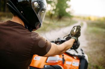 Atv rider adjusts the rearview mirror before the trip. Offroad travelling on quad bike, active extreme motor sport