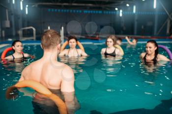 Trainer and female group, fitness workout in swimming pool. Aqua aerobics training, water sport 