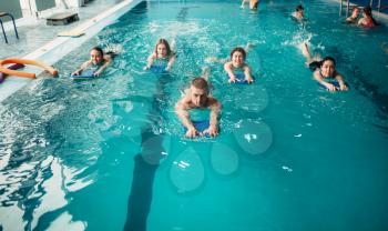 Male trainer swims with female aqua aerobics group on workout in swimming pool. Water sport