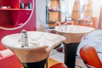 Modern wash basins in hairdressing salon, nobody. Professional hairdresser equipment, haircut tools in beauty studio