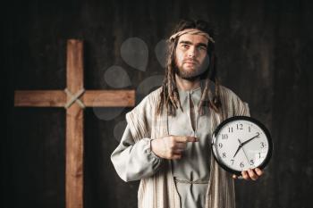 Man in the image of Jesus Christ shows on clock, even God can not turn back time, crucifixion cross on black background
