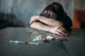 Female junkie hand hand reaching for the dose on the table. Drug addiction concept
