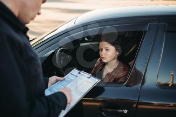Policeman in uniform writes a fine to female driver. Law protection, car traffic inspector, safety control job