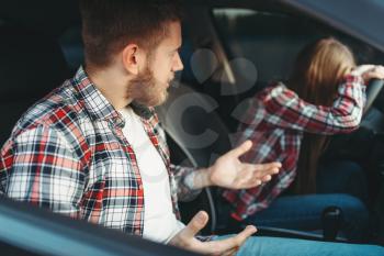 Male driving instructor and sad female student in vehicle, bad exam, car school concept. Test for beginner