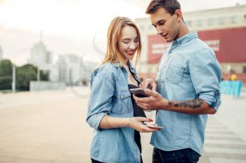 Phone addiction, addict man shows his social page to young woman. Addicted people, modern relationship