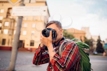 Man takes pictures of tourist attractions of the city on the camera. Summer travelling, hike adventure over sightseeing