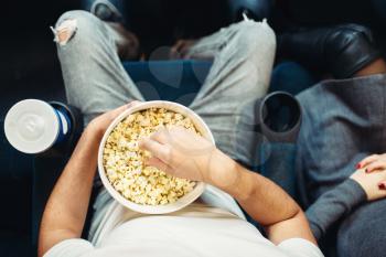 Male person with popcorn in cinema, top view. Movie entertainment, showtime