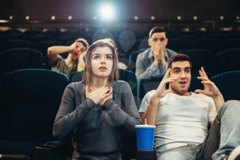 Couple with popcorn fascinated watching the film in cinema. Showtime, entertainment industry