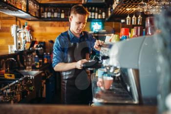 Male bartender prepares drink at the bar counter. Barkeeper occupation, barman working in pub
