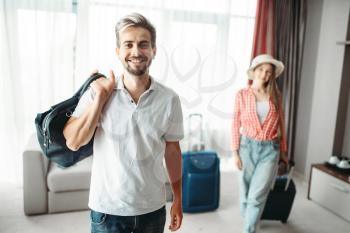 Young man and woman with suitcases went on a journey. Fees on vacation concept. Luggage preparation. Travelling or tourism