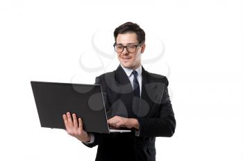 Young businessman in tie and black suit using laptop, isolated on white background