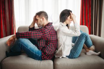 Young couple sitting back to back on couch, bad relationship. Unhappy man and woman in quarrel
