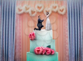 Wedding cake with bride and groom statuettes on the top. Bridal pie for newlyweds with little figurines, traditional celebration ceremony symbol
